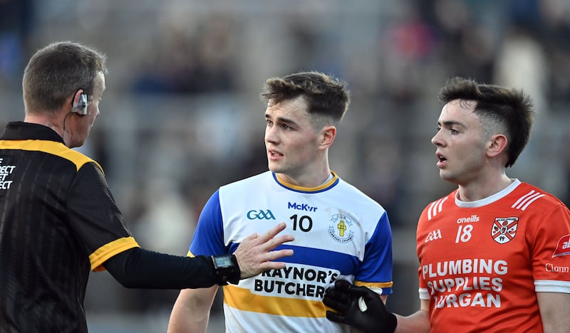 Referee Joe McQuillan speaks to Errigal Ciaran's Ruairi Canavan and his marker Emmet Magee of Clann Eireann.