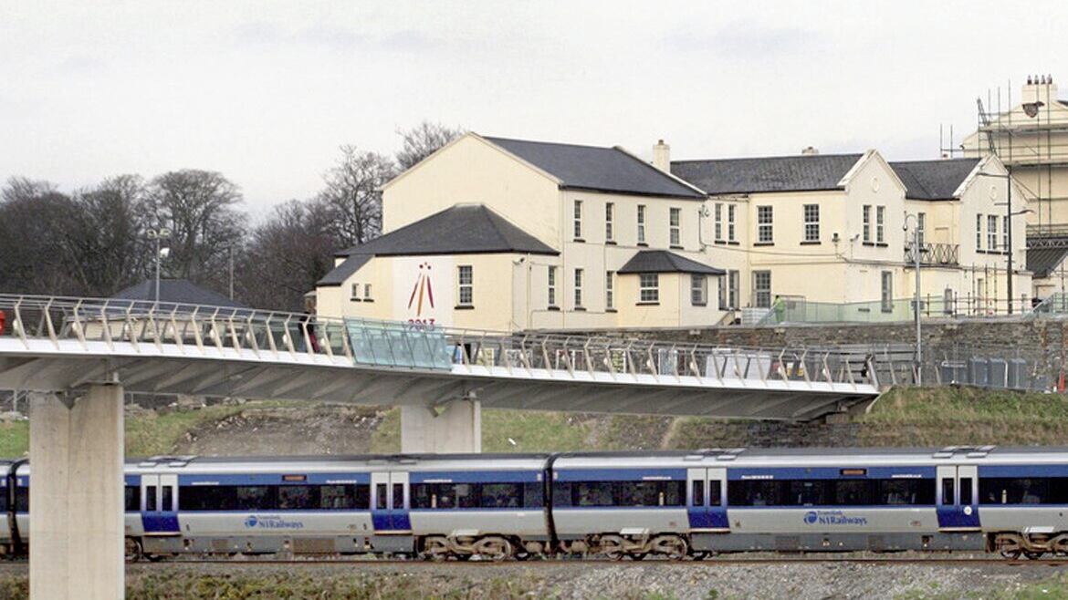 A train runs under the Peace Bridge in Derry
