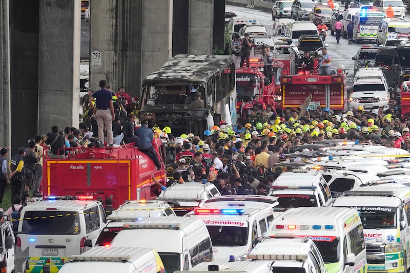 Rescuers gathered at the site of the bus fire in suburban Bangkok (Sakchai Lalit/AP)