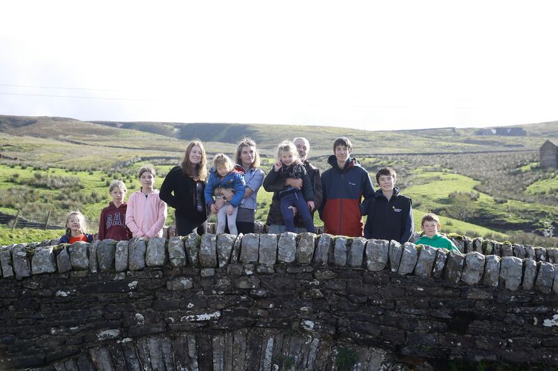 Amanda and Clive Owen with their children Annas, Violet, Edith, Raven, Clemmy, Nancy, Reuben, Miles, and Sidney outside on Ravenseat Farm