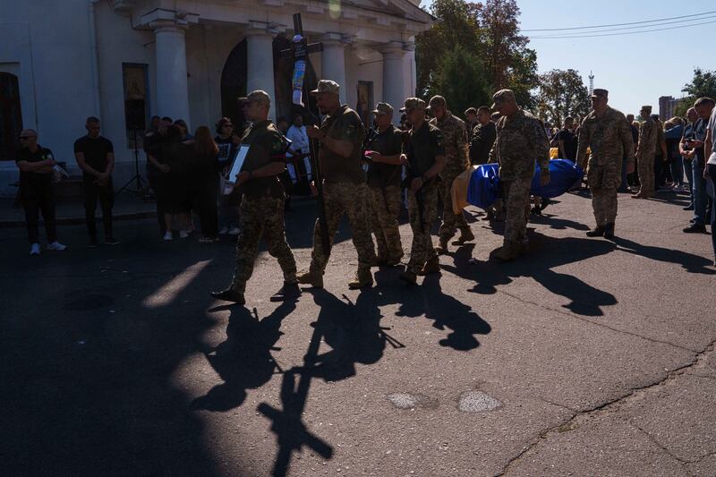 Ukrainian servicemen carry the coffin of a comrade who was killed in a Russian rocket attack on a Ukrainian military academy at his funeral in Poltava (Evgeniy Maloletka/AP)