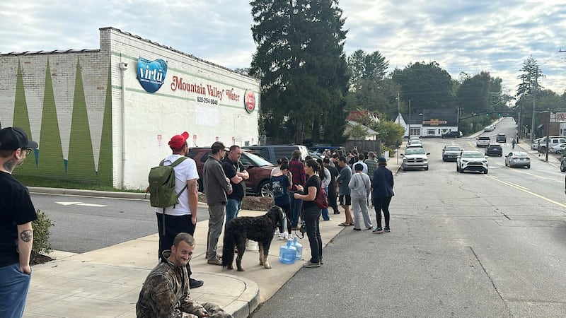 People queued for water in West Asheville in the wake of the hurricane (Jeffrey Collins/AP)