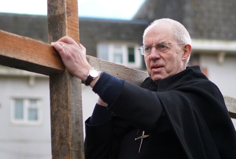 The Archbishop of Canterbury Justin Welby carries a wooden cross as he takes part in the Walk of Witness in Maidstone, Kent on Good Friday