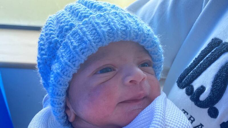 A newborn baby in a blue knitted hat