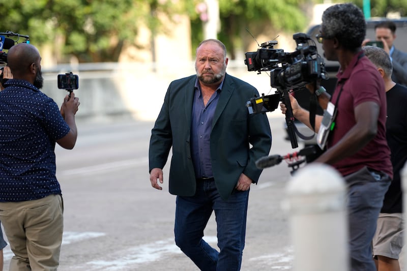 Alex Jones arrives at court for the hearing in front of a bankruptcy judge on Friday (David J Phillip/AP)