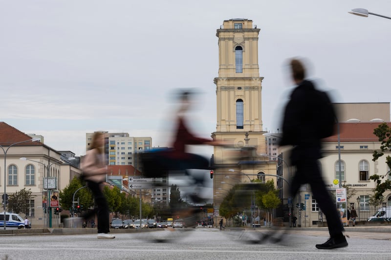 Passers-by walk in front of the tower of the Garrison Church in the city centre in Potsdam, Germany (Christoph Soeder/AP)