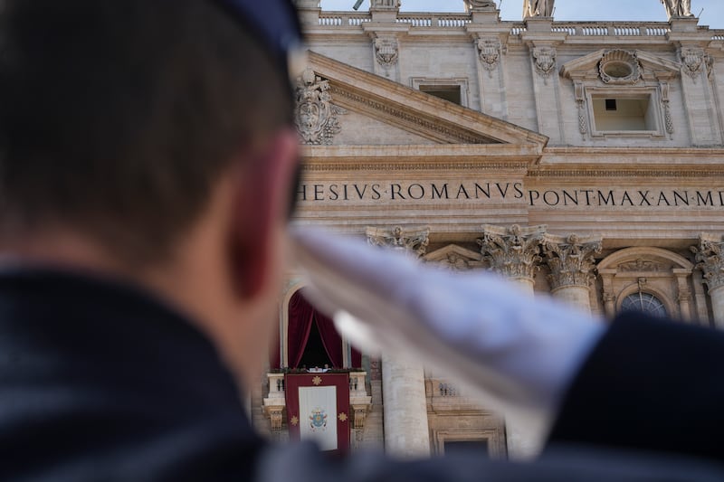 A Vatican gendarmerie officer salutes as Pope Francis prepares to deliver the Urbi et Orbi Christmas Day blessing from the main balcony of St Peter’s Basilica (Andrew Medichini/AP)