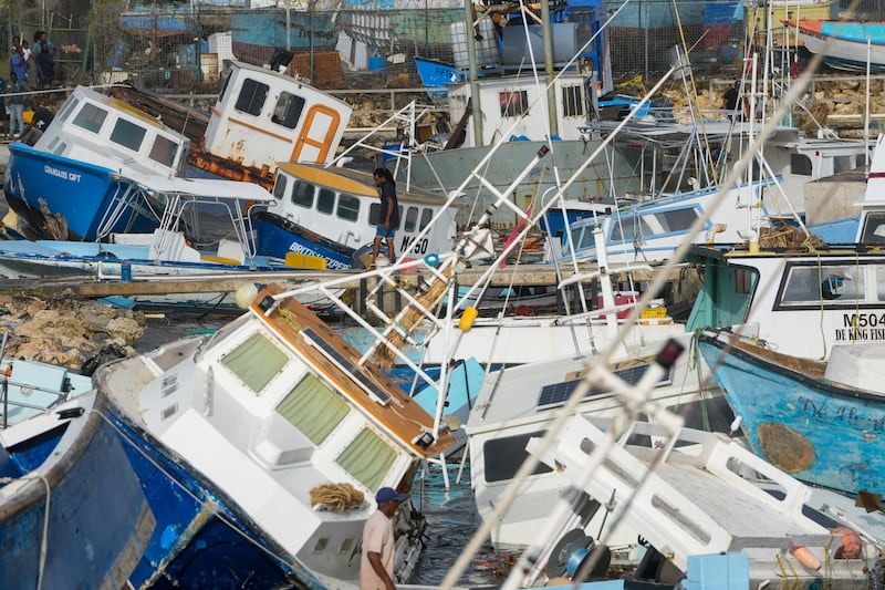 A fisherman looks at fishing vessels damaged by Hurricane Beryl at the Bridgetown Fisheries in Barbados (Ricardo Mazalan/AP)