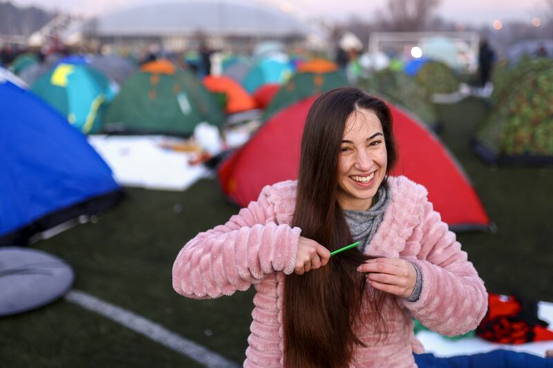 A student brushes her hair after waking up at a soccer stadium during a protest over the collapse of a concrete canopy that killed 15 people in Serbia (Armin Durgut/AP)