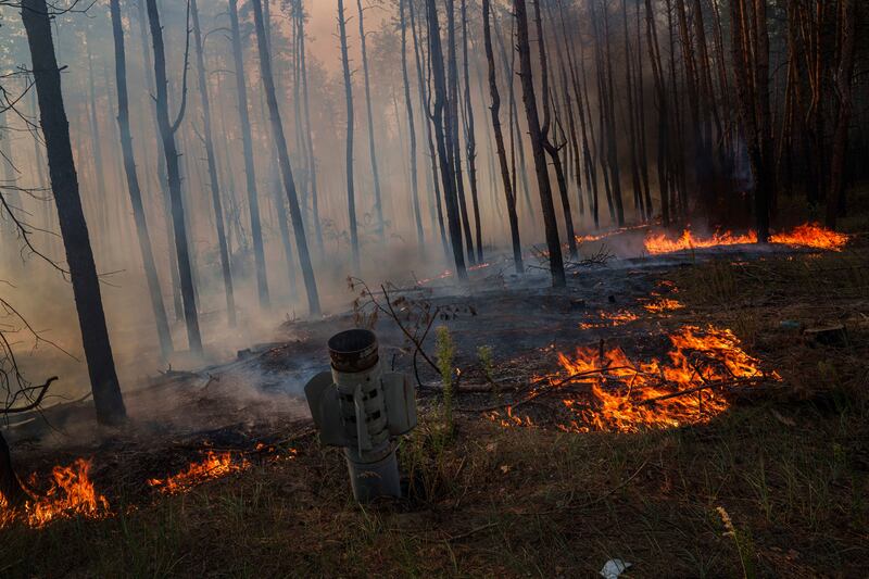 An MSLR rocket stick is seen in the ground in a forest fire after a Russian strike near Sloviansk in the Donetsk region, Ukraine, on Saturday (Evgeniy Maloletk/AP)