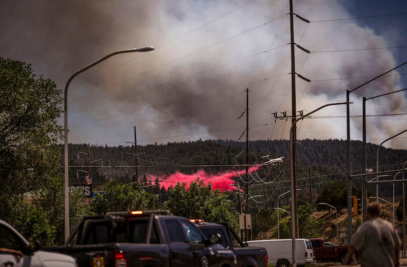 An air tanker drops fire retardant called slurry over and around wildfire-affected areas in the village of Ruidoso(Chancey Bush/The Albuquerque Journal via AP)