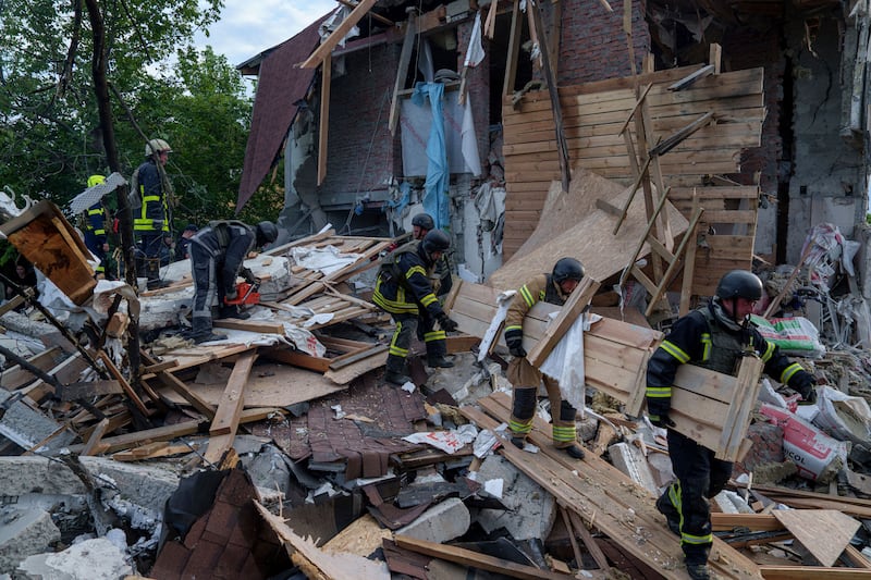 Rescue workers clear the rubble of a building which was destroyed by a Russian airstrike in Kharkiv (Evgeniy Maloletka/AP)