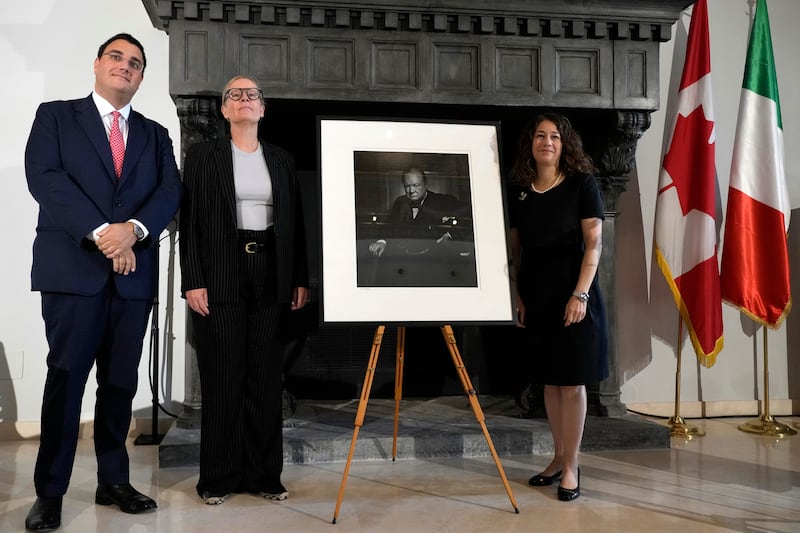 Nicola Cassinelli, an Italian lawyer and occasional art collector, Canadian heritage minister Isabelle Mondou and ambassador of Canada to Italy, Elissa Goldberg, pose next to the portrait (Alessandra Tarantino/AP)