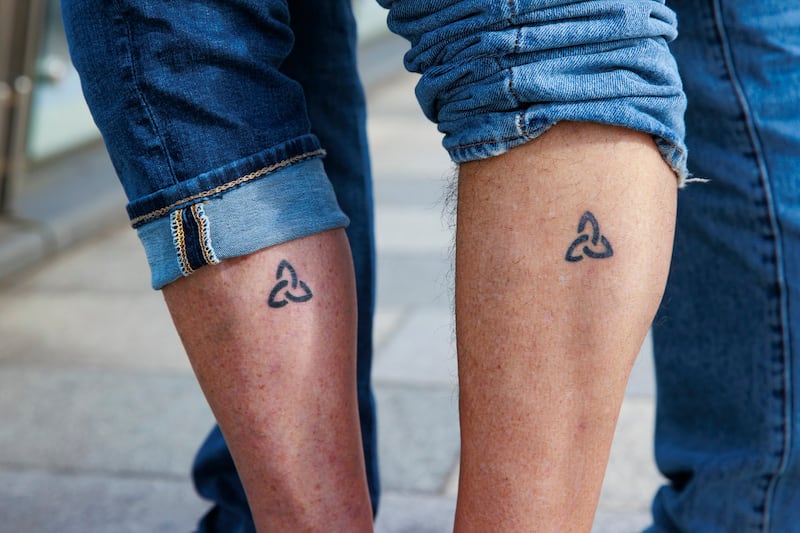 Angela Harsanyi and Gian Perroni show off their matching Trinity tattoos