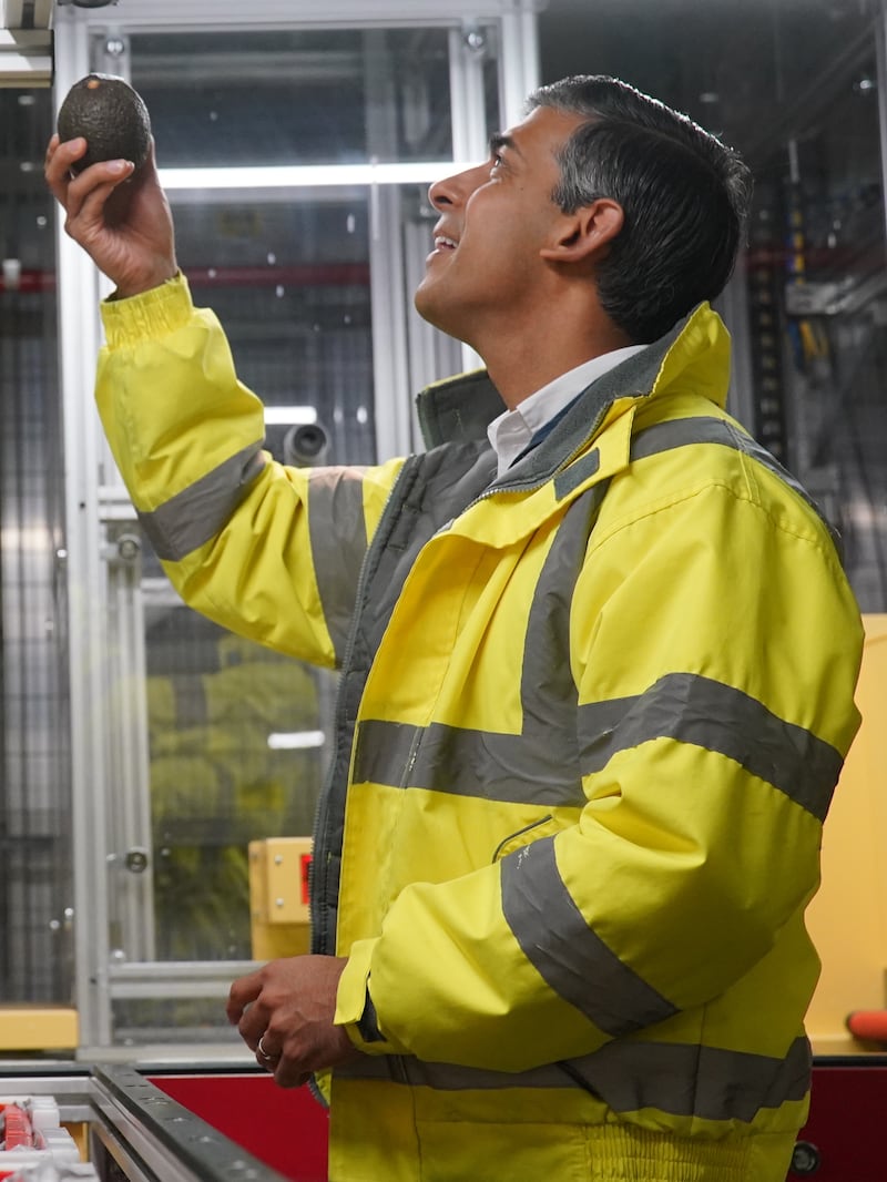 Rishi Sunak inspects an avocado during a campaign visit to an Ocado distribution warehouse in Luton
