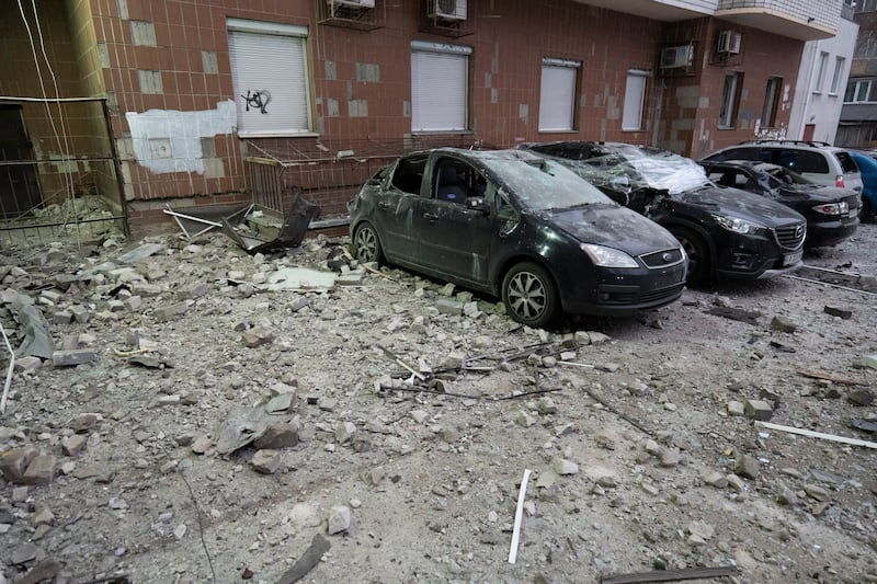 Damaged cars are parked in the yard amid debris after a Russian drone hit a multi-storey apartment house in Kyiv, Ukraine (Dan Bashakov/AP)