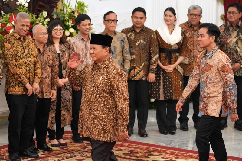 Indonesia’s new President Prabowo Subianto, foreground, and Vice President Gibran Rakabuming Raka, right, greet newly-appointed deputy ministers during the announcement of their cabinet (Achmad Ibrahim/AP)