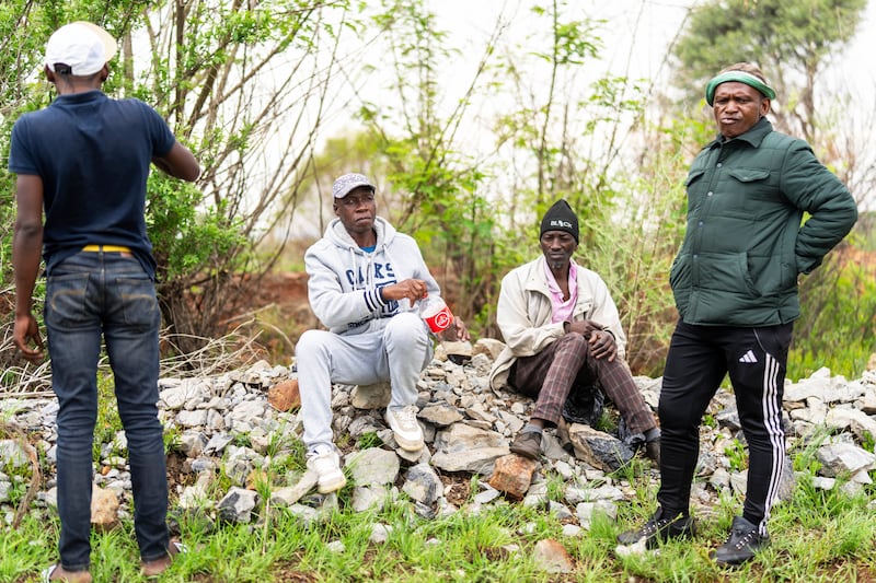 Relatives of miners and community members wait near the shaft of a closed mine where illegal miners are inside in Stilfontein, South Africa (Jerome Delay/AP)