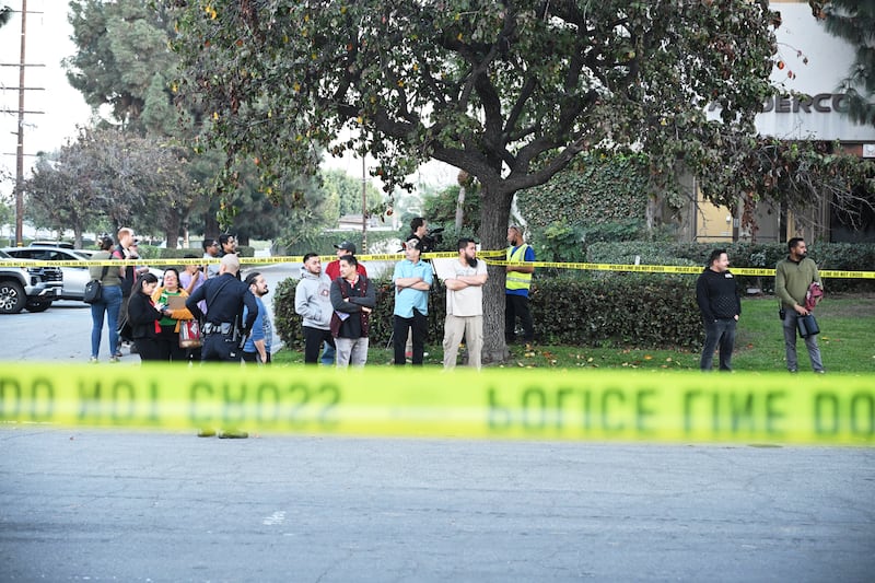 Workers stand near police lines at the scene of the plane crash (Kyusung Gong/AP)