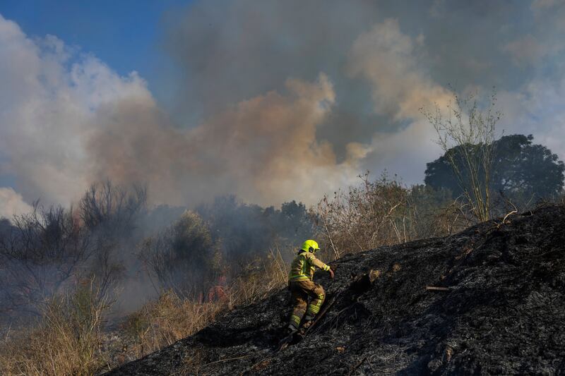 A firefighter works in the area around a fire after the Israeli military fired interceptors at a missile launched from Yemen (Ohad Zwigenberg/AP)