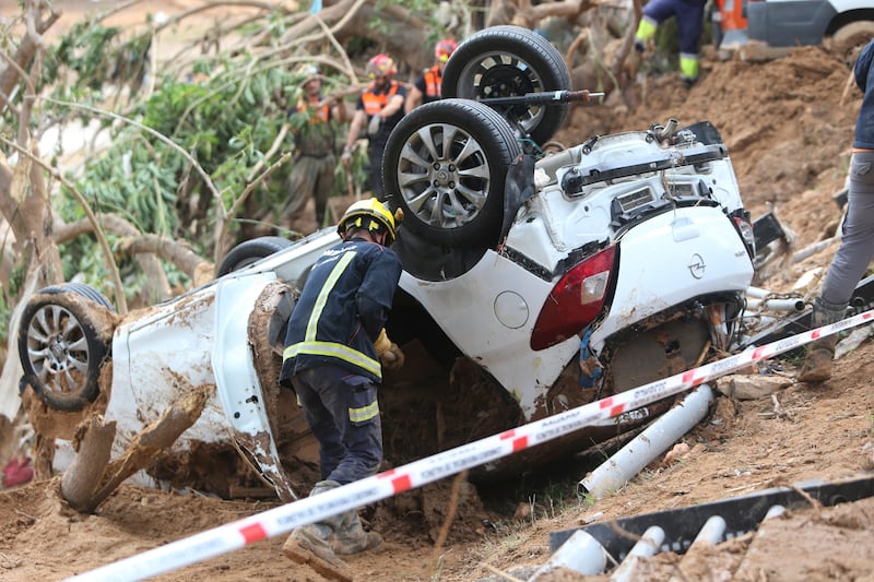 A rescue worker checks a car after floods in Paiporta near Valencia, Spain (Hugo Torres/AP)