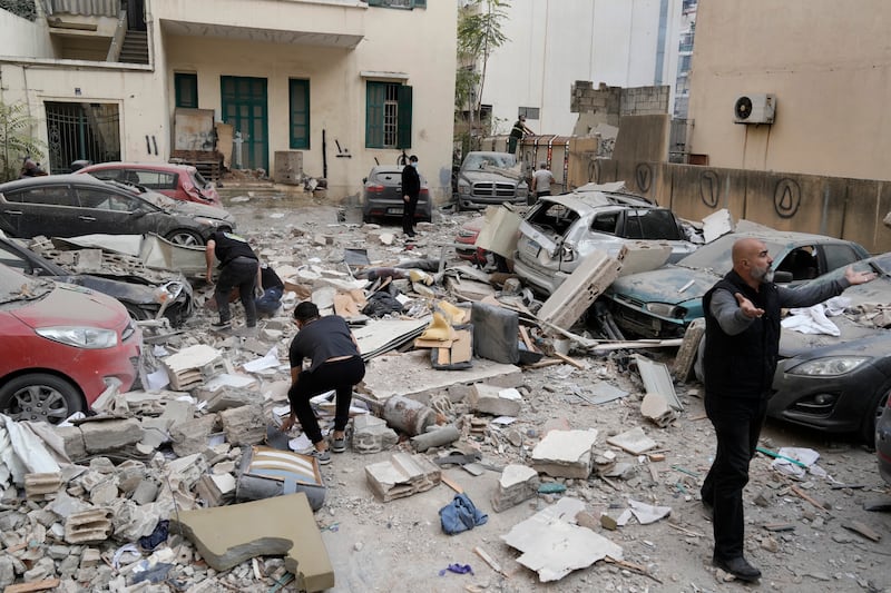 People search through the rubble of a destroyed building at the site of an Israeli air strike in central Beirut (Bilal Hussein/AP)