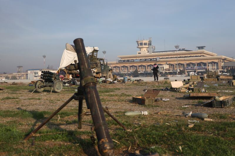 Military equipment is scattered outside Aleppo International Airport as opposition fighters take control of the facility (Omar Albam/AP)