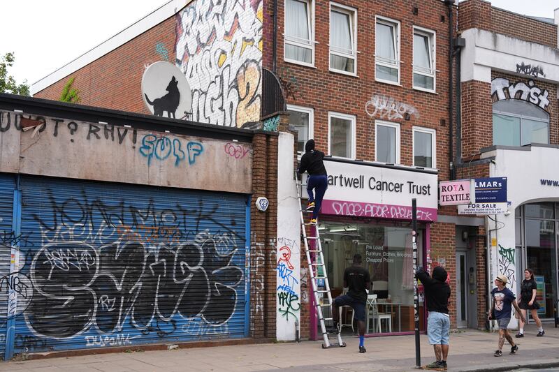 A man used a ladder to reach the artwork which was on a shop roof in Peckham, south-east London