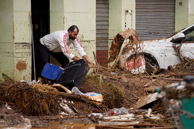 A man cleans his house affected by floods in Valencia (Alberto Saiz/AP)