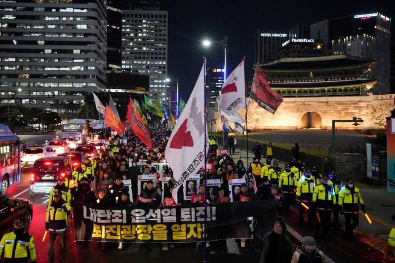 Protesters march to the presidential office after a candlelight vigil against South Korean President Yoon Suk Yeol (Ahn Young-joon/AP)