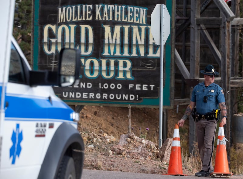 A police officer moves a barrier for an emergency vehicle (Arthur H Trickett-Wile/The Gazette via AP)