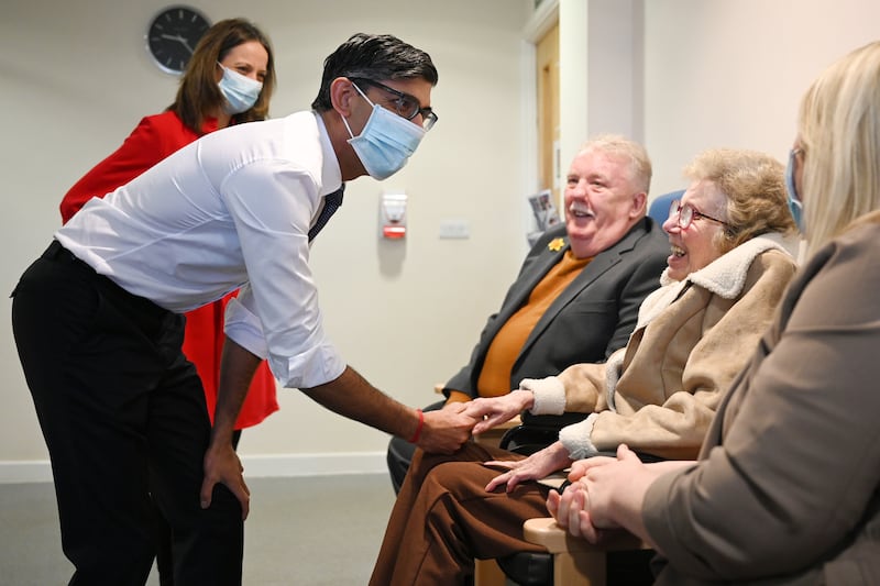 Former Prime Minister Rishi Sunak wearing a face mask during a visit to a healthcare centre