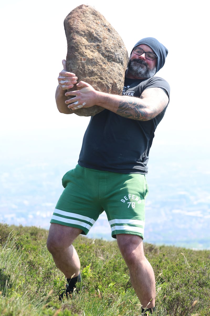 David Keohan from Waterford city lifts a large stone on Black Mountain in West Belfastand. David holds a kettlebell-lifting world record and was in West Belfast for the Féile na gCloigíní Gorma (Blue Bell Festival). Stone lifting was a tradition in Scotland, Iceland the Basque Country and Ireland. PICTURE: MAL MCCANN