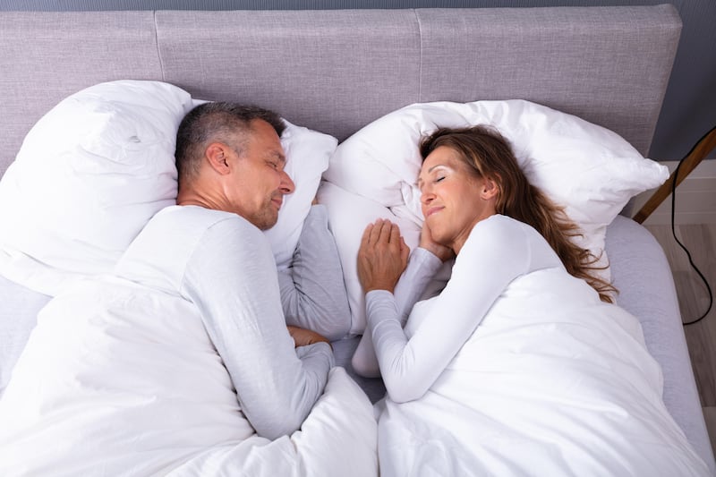 High angle view of middle age couple sleeping in bed