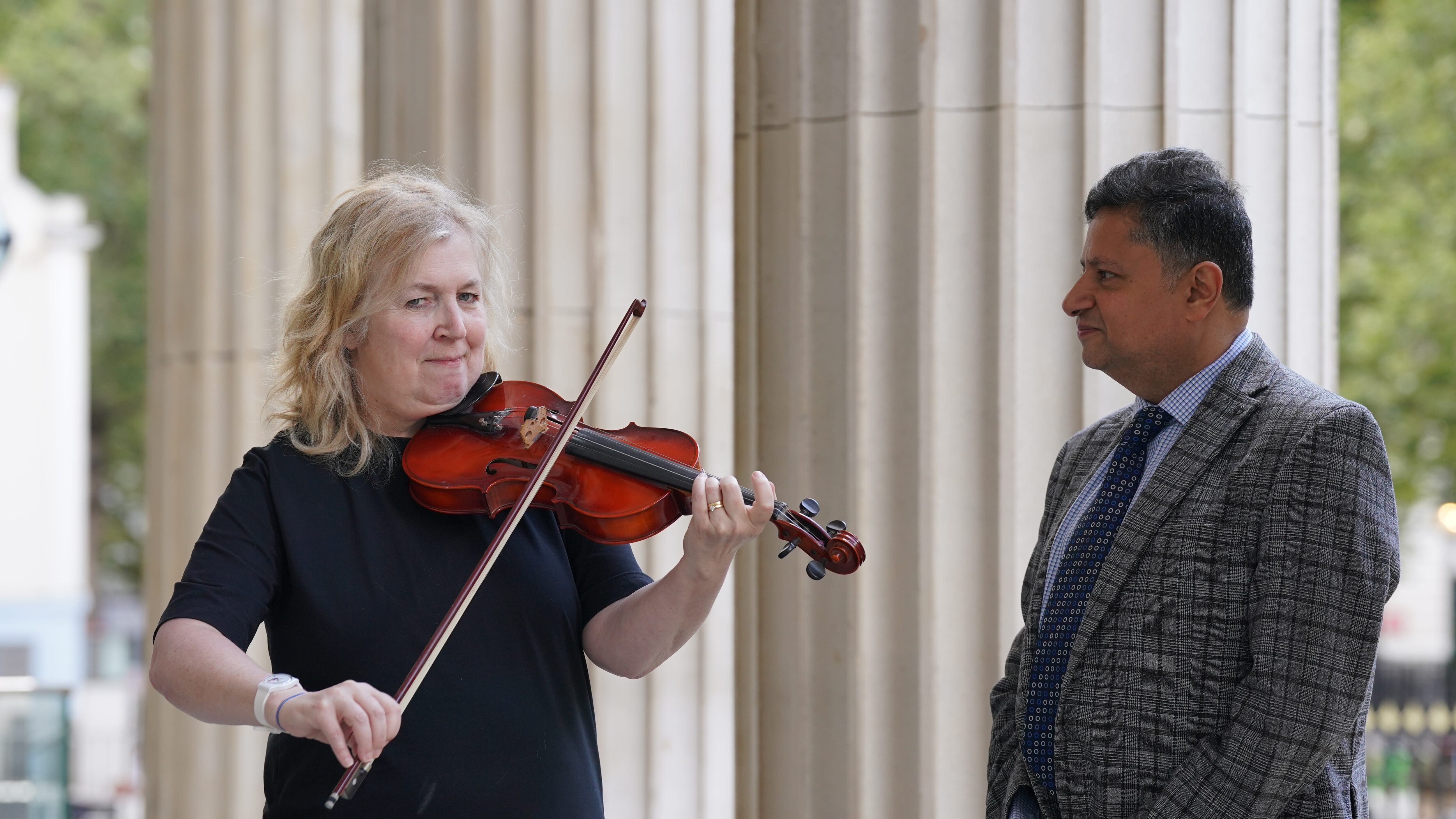 Dagmar Turner, who played the violin while surgeons removed a tumour from her brain, has been reunited with consultant neurosurgeon Professor Keyoumars Ashkan after two-and-a-half years (Lucy North/PA)