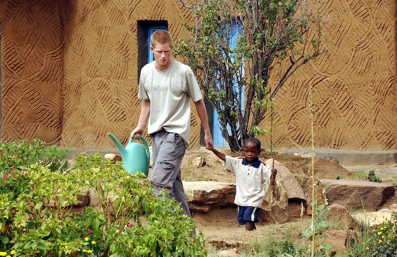 Harry leading young orphan Mutsu Potsane, four, by the hand to plant a peach tree together at the Mants’ase Children’s Home for orphans near Mohale’s Hoek