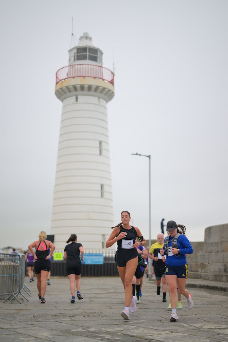 Group of runners in 5k race in front of white lighthouse