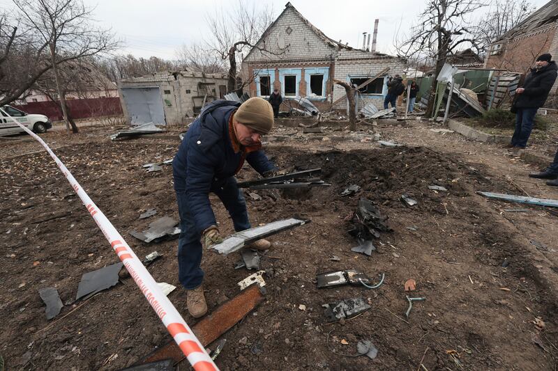 A police forensic expert inspects fragments of a Shahed drone, after a Russian strike on residential neighbourhood in Zaporizhzhia, Ukraine (Kateryna Klochko/AP)