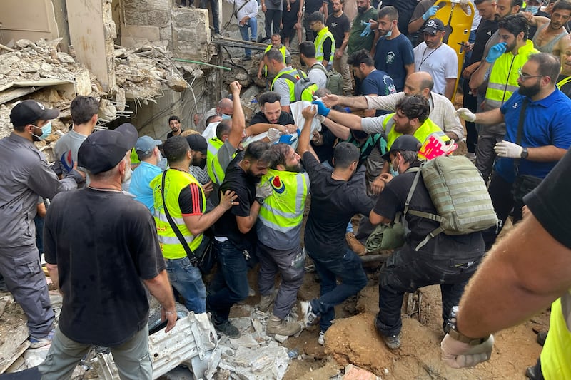 Rescuers carry a body at the scene of a missile strike in the southern suburbs of Beirut (Bilal Hussein/AP)