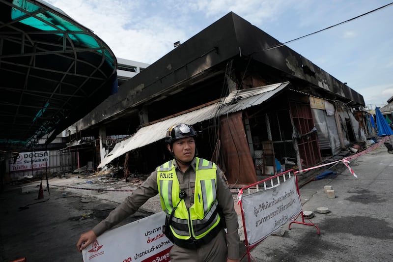 A Thai police officer stands by the pet zone area after a fire at Chatuchak Weekend Market (Sakchai Lalit/AP)