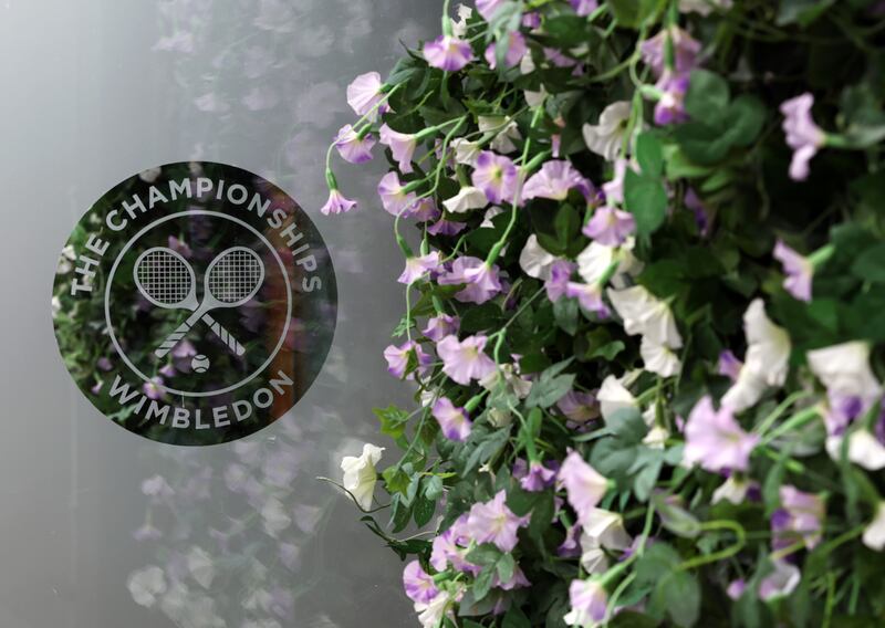 A general view of the Wimbledon logo next to a wall of flowers