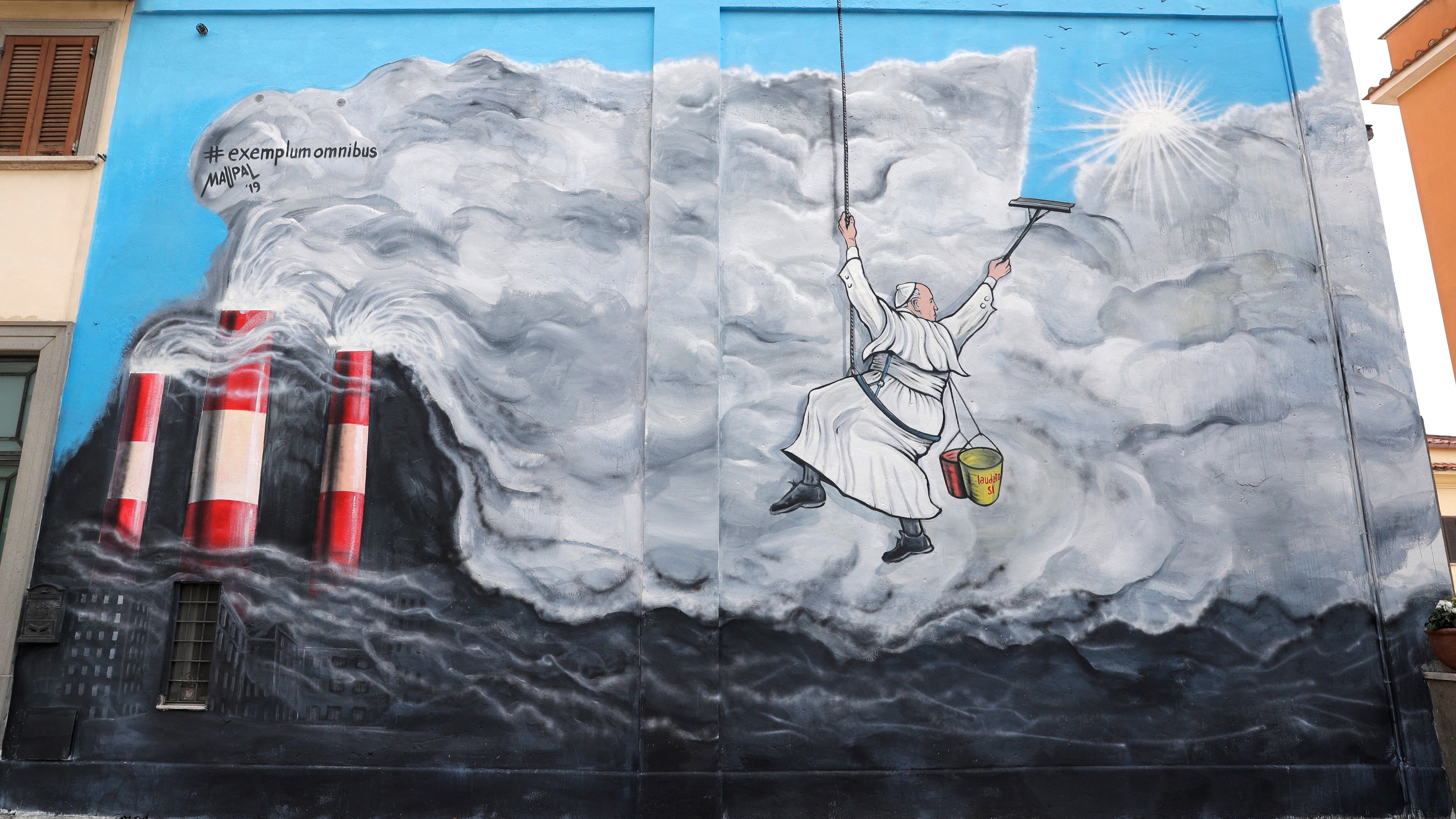 Graffiti depicting Pope Francis cleaning the sky from pollution (Andrew Medichini/AP)