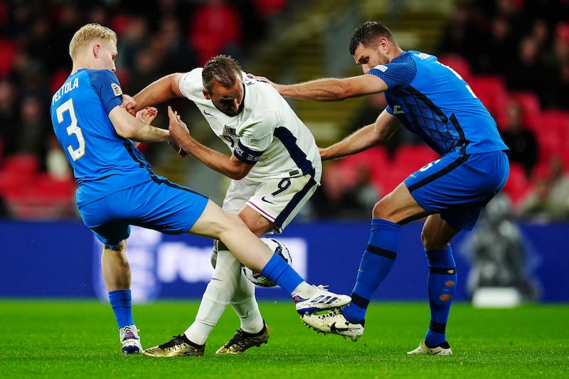 Kane ,centre, fighting two Finland player for possession