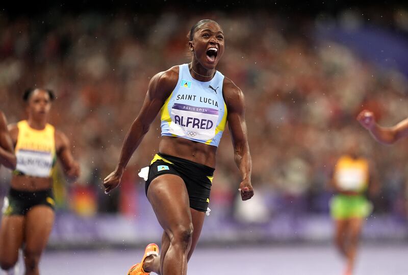 Julien Alfred celebrates winning the 100m final