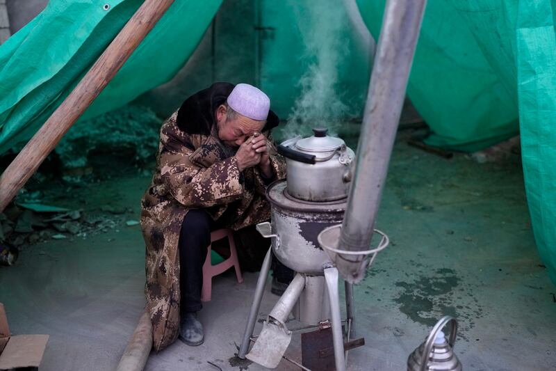 Ma Chengyun grieves for his daughter-in-law in Yangwa village near Dahejia town (AP)