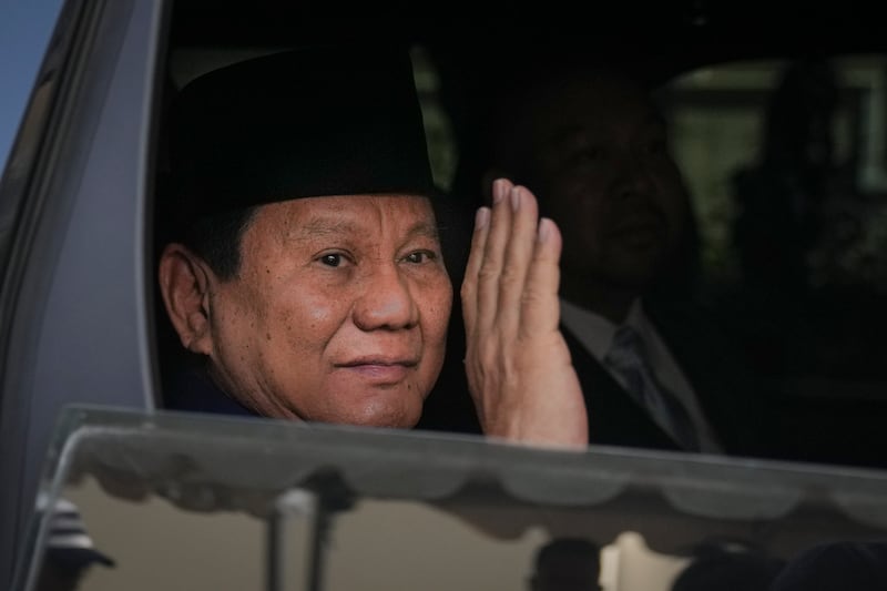 Prabowo Subianto waves as he is driven to his inauguration ceremony in Jakarta (Dita Alangkara/AP)