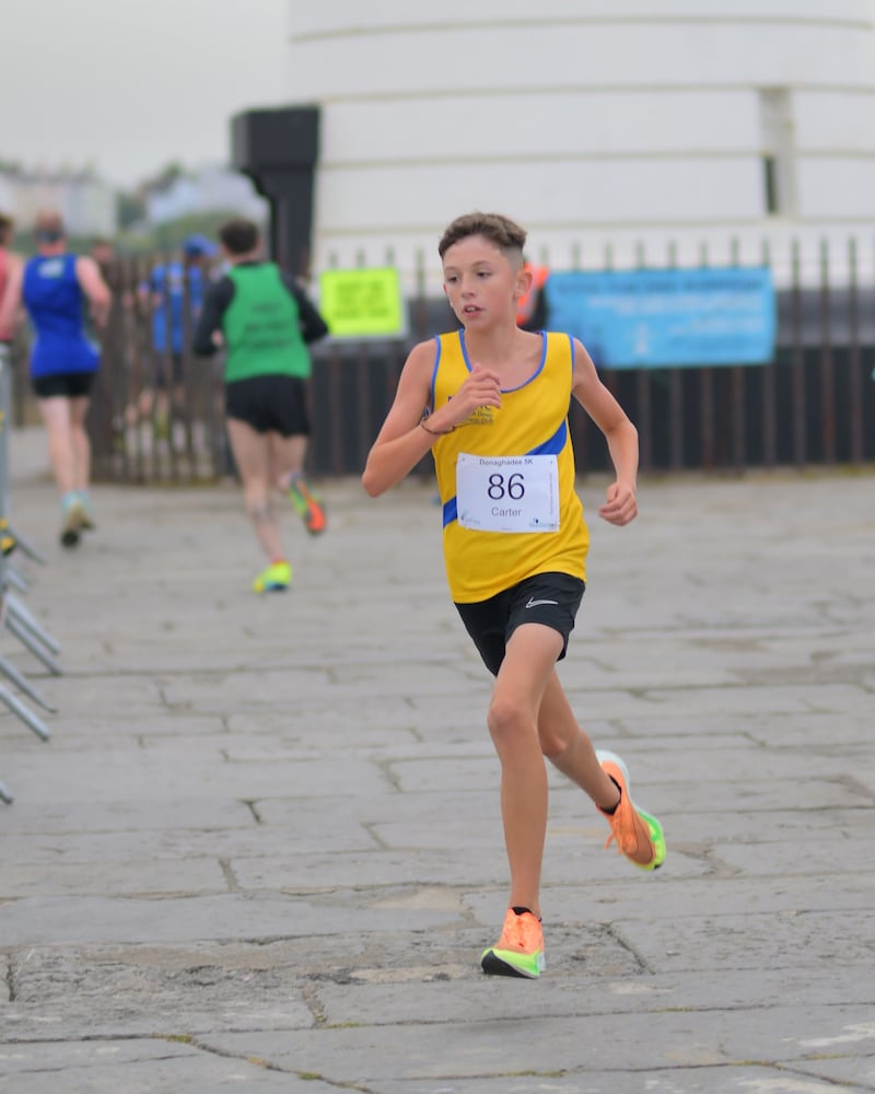 Group of runners in 5k race in front of white lighthouse