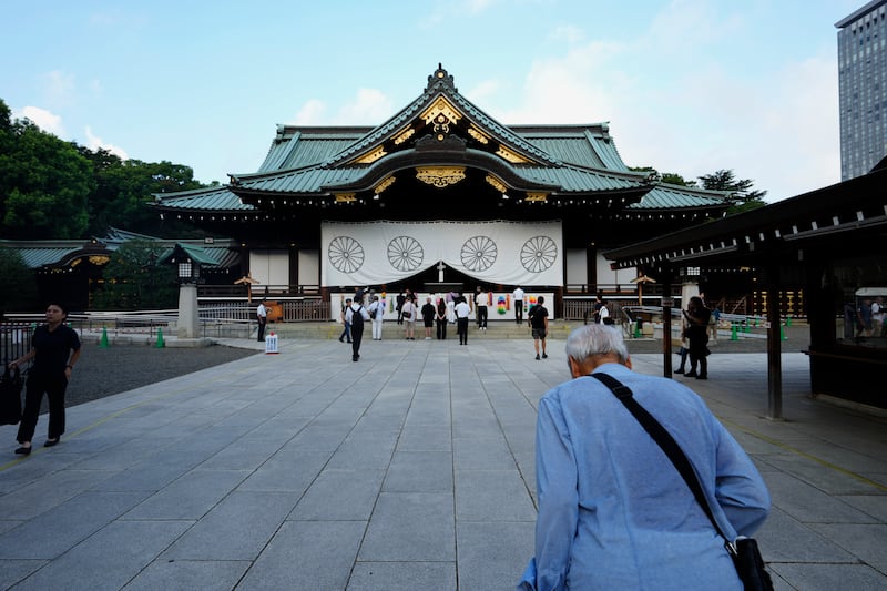 A man bows in front of the main hall of the Yasukuni Shrine (Hiro Komae/AP)