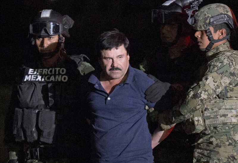 Videos posted on social media have shown one of the daughters of imprisoned drug lord Joaquin &quot;El Chapo&quot; Guzman handing out boxes of rice, pasta, cooking oil and toilet paper with Guzman's image printed on them. El Chapo is seen here being&nbsp;escorted by army soldiers to a waiting helicopter, at a federal hangar in Mexico City last year