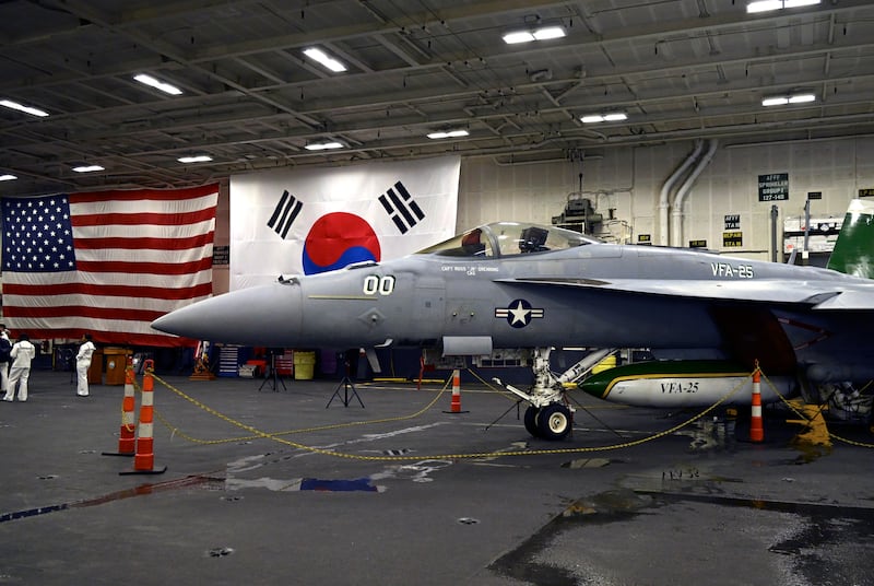 An F-18 fighter aircraft sits in the hangar of the Theodore Roosevelt (CVN 71), a nuclear-powered aircraft carrier, anchored in Busan Naval Base in South Korea (Song Kyung-Seok/Pool Photo via AP)